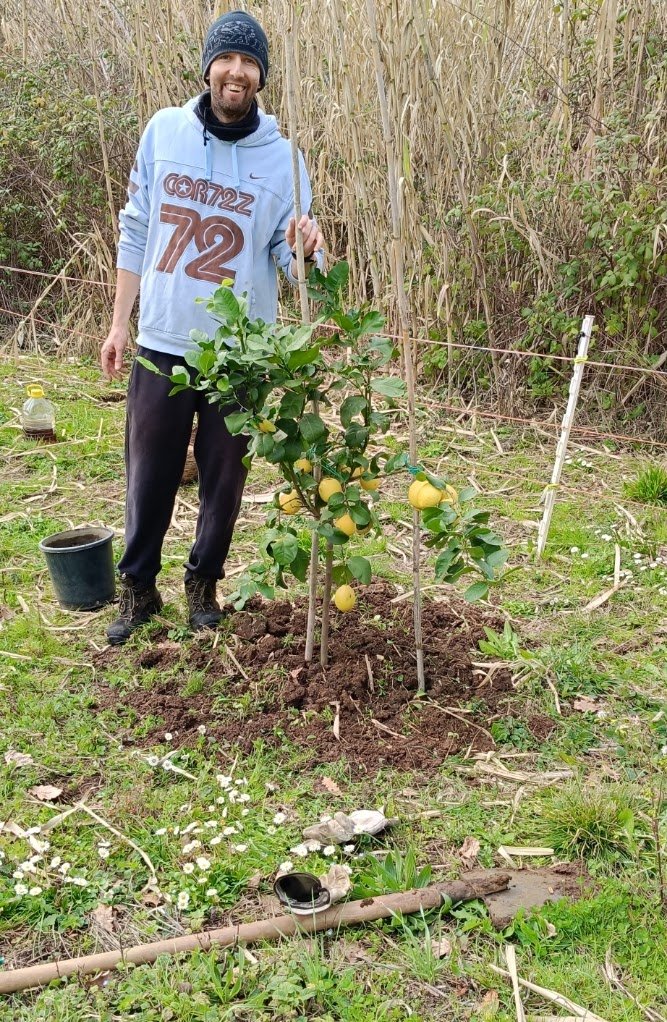 Federico accanto alla pianta di limone appena piantata
